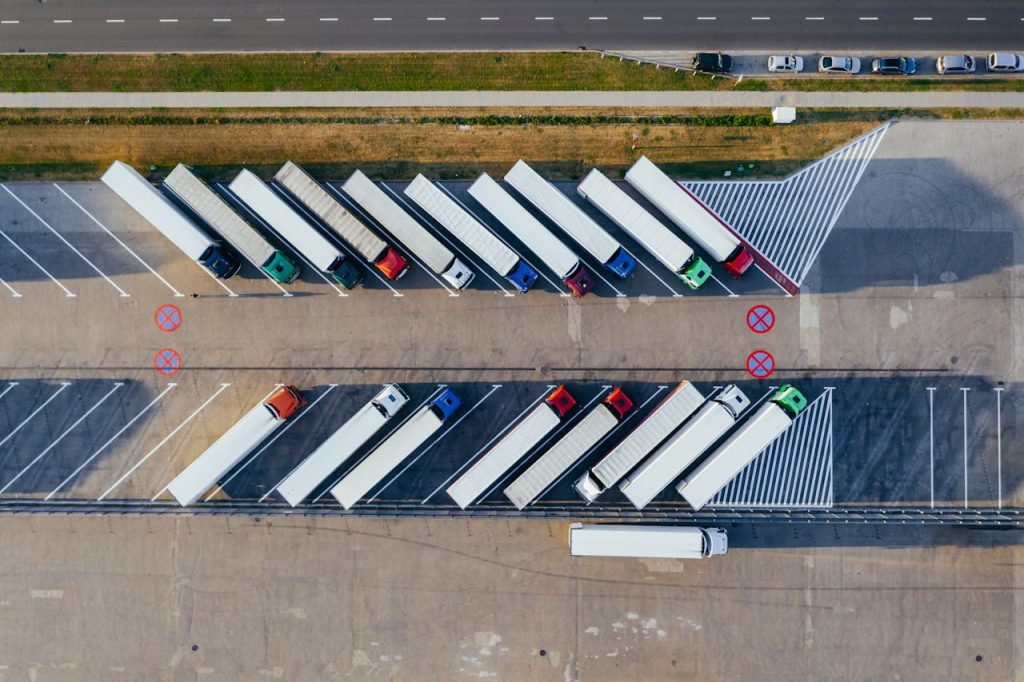 pexels photo 2800121 Overhead shot of semi-trucks parked in Poznań, Poland, demonstrating transportation logistics.